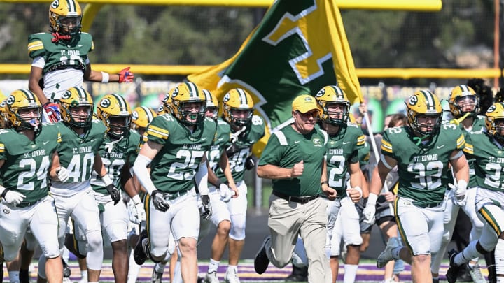 St. Edward takes the field before a football game in 2023, led by head coach Tom Lombardo. 