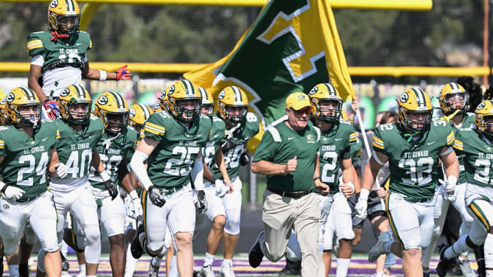 St. Edward head coach Tom Lombardo leads the Eagles onto the field for a game against River Rouge (Michigan) on September 23, 2023.