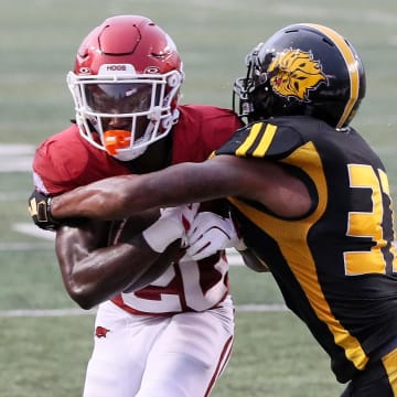 Arkansas Razorbacks running back Rodney Hill (20) rushes for a touchdown in the first quarter as Pine Bluff Golden Lions linebacker Jaylen White (31) defends at War Memorial Stadium.