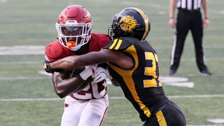 Arkansas Razorbacks running back Rodney Hill (20) rushes for a touchdown in the first quarter as Pine Bluff Golden Lions linebacker Jaylen White (31) defends at War Memorial Stadium.