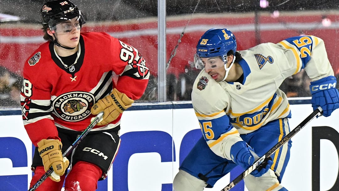 Dec 31, 2024; Chicago, Illinois, USA; Chicago Blackhawks center Connor Bedard (98) skates with the puck against St. Louis Blues center Jordan Kyrou (25) during the third period in the Winter Classic at Wrigley Field. Mandatory Credit: Daniel Bartel-Imagn Images