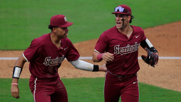 Florida State first baseman Daniel Cantu (32), right, is patted on the back by infielder Cam Smith (24) during the fourth inning of an NCAA baseball matchup at 121 Financial Ballpark in Jacksonville, Fla. Florida State defeated Florida 14-3.