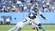 Nov 23, 2025; Nashville, Tennessee, USA; Tennessee Titans running back Tyjae Spears (2) runs against Seattle Seahawks cornerback Riq Woolen (27) during the second half at Nissan Stadium. Mandatory Credit: Steve Roberts-Imagn Images