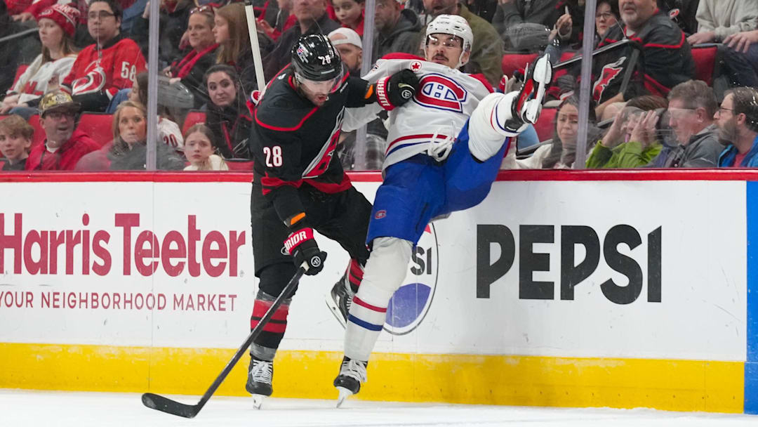 Jan 1, 2026; Raleigh, North Carolina, USA;  Carolina Hurricanes left wing William Carrier (28) checks MontrÈal Canadiens defenseman Arber Xhekaj (72) during the second period at Lenovo Center. Mandatory Credit: James Guillory-Imagn Images