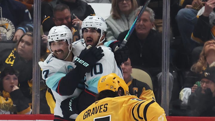 Nov 22, 2025; Pittsburgh, Pennsylvania, USA;  Seattle Kraken right wing Jordan Eberle (7) and center Matty Beniers (10) celebrate a goal by Beniers as Pittsburgh Penguins defenseman Ryan Graves (27) reacts during the third period at PPG Paints Arena. Mandatory Credit: Charles LeClaire-Imagn Images