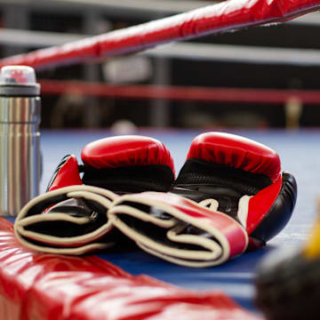 Boxing gloves on an empty ring.