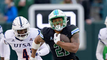 Nov 24, 2023; New Orleans, Louisiana, USA; Tulane Green Wave running back Makhi Hughes (21) runs against UTSA Roadrunners running back Kevorian Barnes (4) during the first half at Yulman Stadium. 