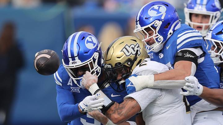 Nov 29, 2025; Provo, Utah, USA; UCF Knights quarterback Tayven Jackson (2) fumbles as BYU Cougars safety Raider Damuni (3) and linebacker Jack Kelly (17) make a tackle during the second half at LaVell Edwards Stadium. Mandatory Credit: Rob Gray-Imagn Images