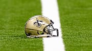 Aug 25, 2024; New Orleans, Louisiana, USA;  New Orleans Saints helmet on the turf during warmups before the game against the Tennessee Titans at Caesars Superdome. Mandatory Credit: Stephen Lew-Imagn Images