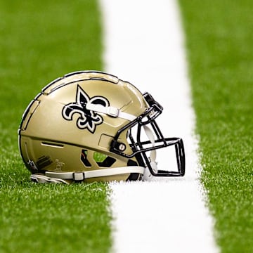 Aug 25, 2024; New Orleans, Louisiana, USA;  New Orleans Saints helmet on the turf during warmups before the game against the Tennessee Titans at Caesars Superdome. Mandatory Credit: Stephen Lew-Imagn Images