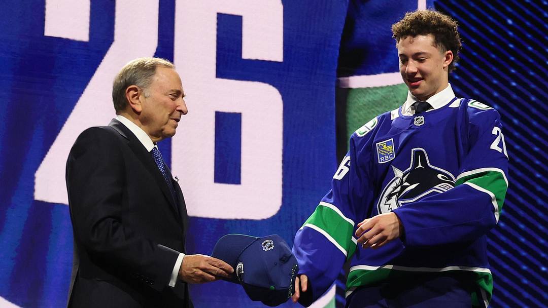 Jun 26, 2026; Buffalo, New York, USA; Caleb Malhotra reacts with NHL commissioner Gary Bettman after being selected with the third pick in the first round of the 2026 NHL Draft by the Vancouver Canucks at KeyBank Center. Mandatory Credit: Timothy T. Ludwig-Imagn Images
