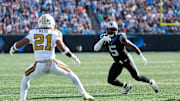 Nov 9, 2025; Charlotte, North Carolina, USA; Carolina Panthers running back Rico Dowdle (5) rushes as New Orleans Saints safety Justin Reid (21) defends during the first quarter at Bank of America Stadium. Mandatory Credit: Jim Dedmon-Imagn Images