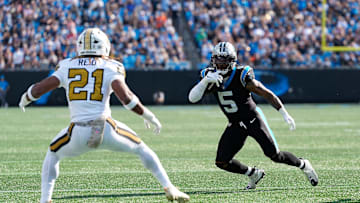 Nov 9, 2025; Charlotte, North Carolina, USA; Carolina Panthers running back Rico Dowdle (5) rushes as New Orleans Saints safety Justin Reid (21) defends during the first quarter at Bank of America Stadium. Mandatory Credit: Jim Dedmon-Imagn Images