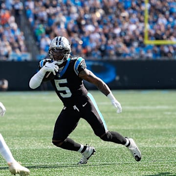 Nov 9, 2025; Charlotte, North Carolina, USA; Carolina Panthers running back Rico Dowdle (5) rushes as New Orleans Saints safety Justin Reid (21) defends during the first quarter at Bank of America Stadium. Mandatory Credit: Jim Dedmon-Imagn Images