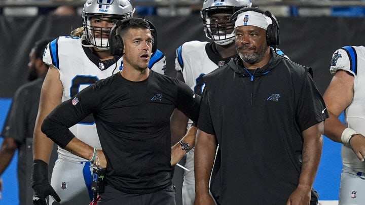 Aug 17, 2024; Charlotte, North Carolina, USA; Carolina Panthers head coach Dave Canales talks with offensive coach Harold Goodwin during the second half against the New York Jets at Bank of America Stadium. 