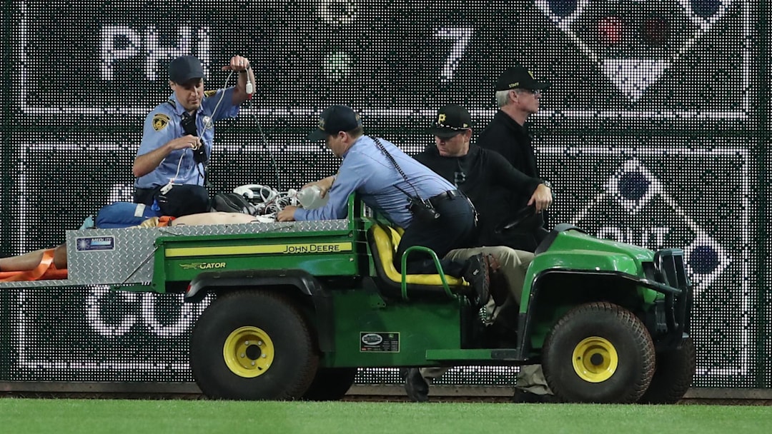 Apr 30, 2025; Pittsburgh, Pennsylvania, USA;  Stadium security and Pittsburgh Pirates medical personnel cart a fan who fell from the stands to the field to an ambulance as the Pirates batted against the Chicago Cubs during the seventh inningat PNC Park. Mandatory Credit: Charles LeClaire-Imagn Images