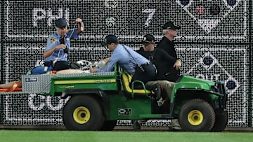 Stadium security and Pittsburgh Pirates medical personnel cart a fan who fell from the stands to the field to an ambulance.