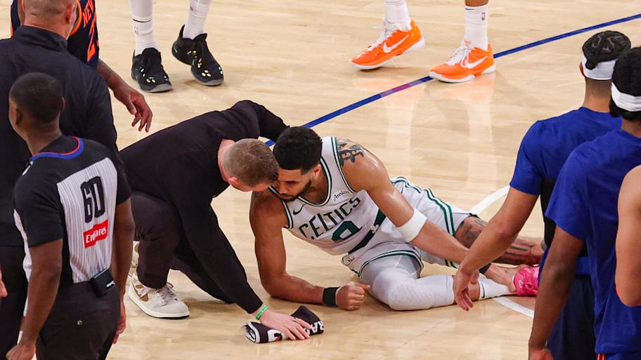 Boston Celtics forward Jayson Tatum with a member of the medical staff on the court after an injury. | Vincent Carchietta-Imagn Images