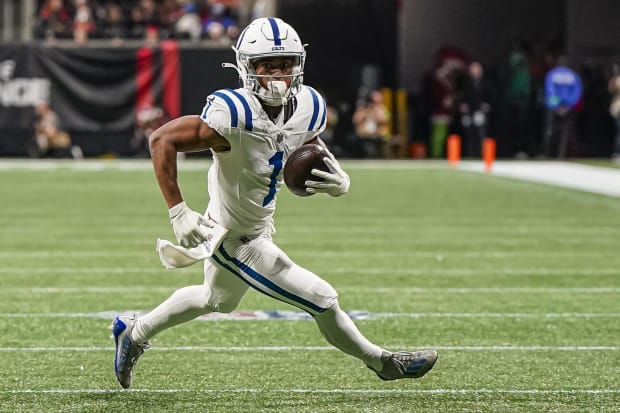 Football player Josh Downs runs after the catch in a white jersey.