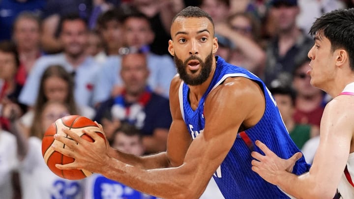 Jul 30, 2024; Villeneuve-d'Ascq, France; France centre Rudy Gobert (27) handles the ball against Japan centre Hugh Watanabe (34) in men’s basketball group B play during the Paris 2024 Olympic Summer Games at Stade Pierre-Mauroy. 