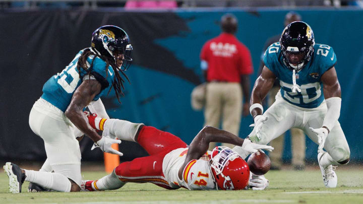 Aug 10, 2024; Jacksonville, Florida, USA; Kansas City Chiefs wide receiver Cornell Powell (14) fumbles the ball and recovers after being hit by Jacksonville Jaguars safety Terrell Edmunds (45) during the fourth quarter at EverBank Stadium. Mandatory Credit: Douglas DeFelice-USA TODAY Sports