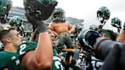 Oct 30, 2021; East Lansing, MI, USA;  Michigan State players celebrate the 37-33 win over Michigan with the Paul Bunyan trophy at Spartan Stadium in East Lansing on Saturday, Oct. 30, 2021. Mandatory Credit: Junfu Han-Imagn Images