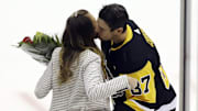 Pittsburgh Penguins center Sidney Crosby embraces girlfriend Kathy Leutner before his 1000th career NHL game. 