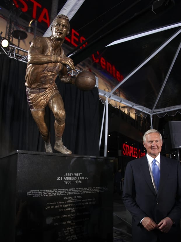 Jerry West stands next to a statue of himself.