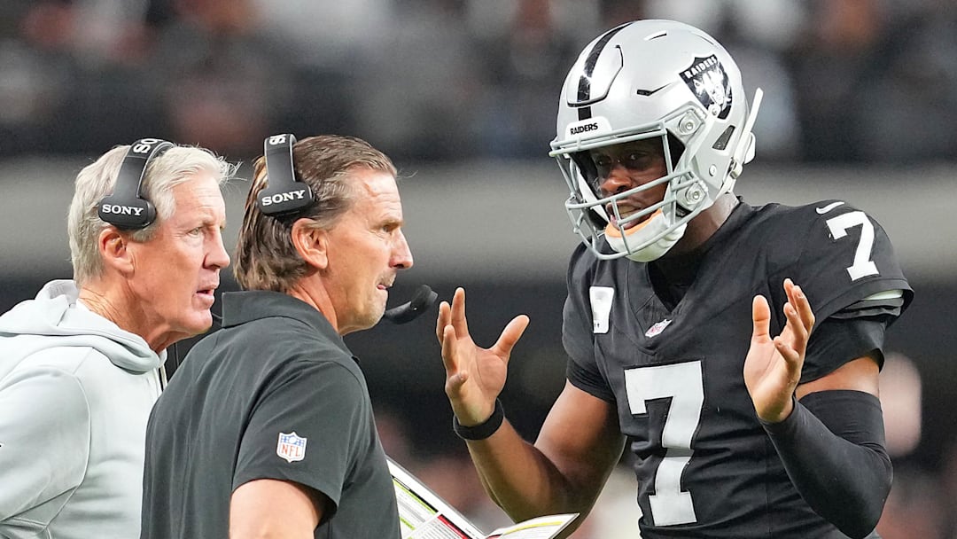 Nov 23, 2025; Paradise, Nevada, USA; Las Vegas Raiders quarterback Geno Smith (7) talks with head coach Pete Carroll and quarterbacks coach Greg Olsen in a game against the Cleveland Browns during the fourth quarter at Allegiant Stadium. Mandatory Credit: Stephen R. Sylvanie-Imagn Images