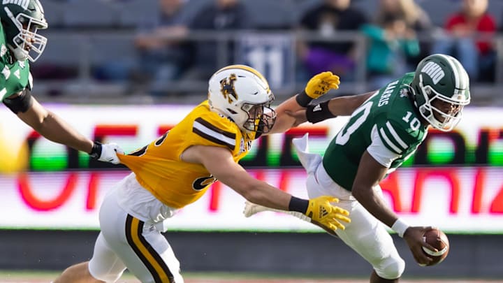 Dec 30, 2022; Tucson, AZ, USA; Ohio Bobcats quarterback CJ Harris (10) against Wyoming Cowboys defensive end Braden Siders (86) during the 2022 Barstool Sports Arizona Bowl at Arizona Stadium. Mandatory Credit: Mark J. Rebilas-Imagn Images