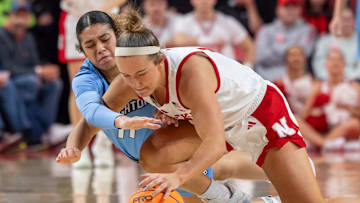 Nebraska guard Callin Hake and Creighton guard Kiani Lockett fight for the loose ball.