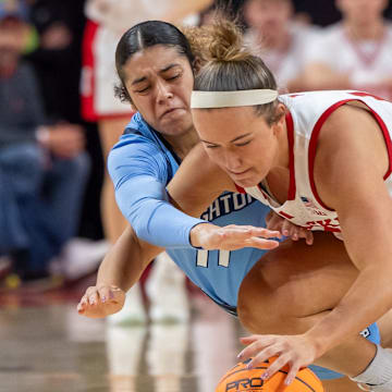 Nebraska guard Callin Hake and Creighton guard Kiani Lockett fight for the loose ball.