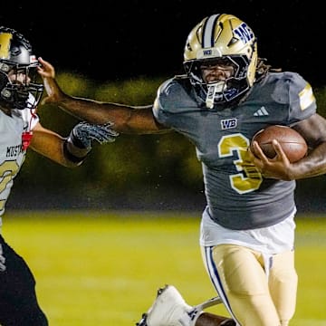 West Boca running back Javian Mallory (3) avoids a tackle against Mitchell safety Robert Dunning (21) in the third quarter on Nov. 28, 2025, in Boca Raton, FL.