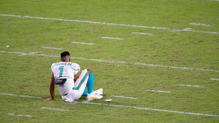 Miami Dolphins quarterback Tua Tagovailoa (1) sits on the field after spending some time alone after