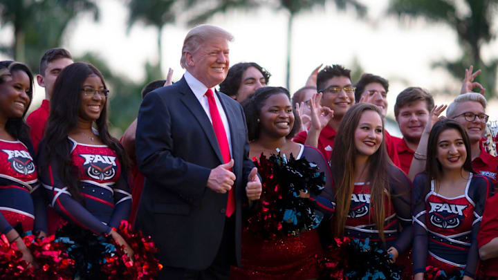 President Donald J. Trump poses for a photo with Florida Atlantic University cheerleaders and members of the marching band outside Trump International Golf Club, Sunday, February 3, 2019. President Trump was arriving for his annual Super Bowl watch party at his golf club in West Palm Beach. [ALLEN EYESTONE/palmbeachpost.com]