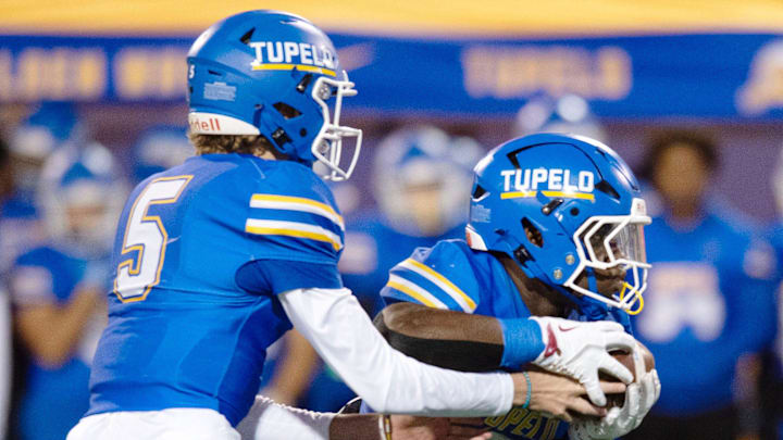 Tupelo quarterback Noah Gillon (5) hands off to Jaeden Hill (0) during play against Brandon in the MHSAA 7A championship game in Hattiesburg, Miss., Thursday, Dec. 5, 2024.