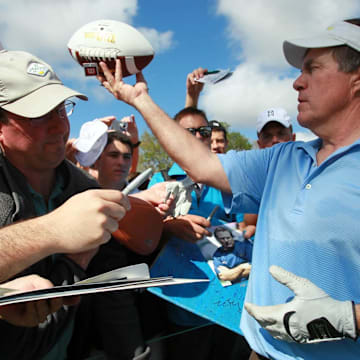 New England Patriots head coach Bill Belichick signs autographs during his pro-am appearance with golfing great Greg Norman, golf star Lexi Thompson, former NFL quarterback and TV commentator Joe Theismann and musician Kenny G at the Honda Classic in 2012.