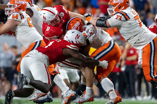 Nebraska defensive linemen Nash Hutmacher and Jimari Butler combine to bring down Illinois running back Kaden Feagin.