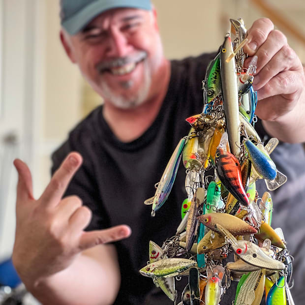 The author holding up a large tangled mes of bass fishing lures.