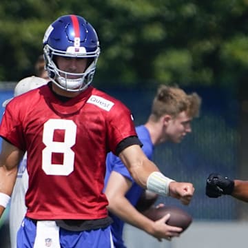 Jul 26, 2023; East Rutherford, NJ, USA; New York Giants quarterback Daniel Jones (8) and running back Saquon Barkley (26) fist-bump on the first day of training camp at the Quest Diagnostics Training Facility.  