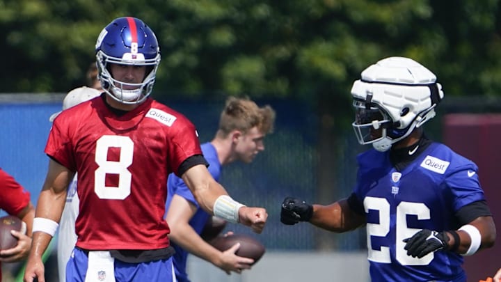 Jul 26, 2023; East Rutherford, NJ, USA; New York Giants quarterback Daniel Jones (8) and running back Saquon Barkley (26) fist-bump on the first day of training camp at the Quest Diagnostics Training Facility.  