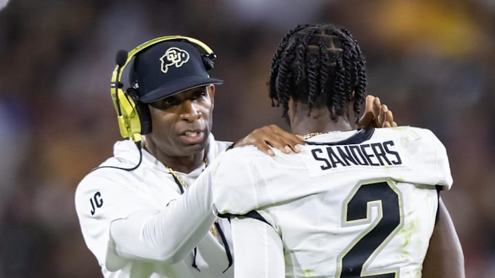 Colorado head coach Deion Sanders talks with his son quarterback Shedeur Sanders during a game. Colorado head coach Deion Sanders talks with his son quarterback Shedeur Sanders during a game.