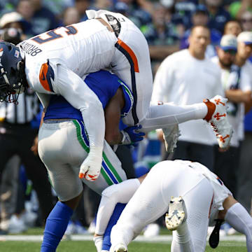 Sep 8, 2024; Seattle, Washington, USA; Denver Broncos linebacker Baron Browning (5) tackles Seattle Seahawks running back Kenneth Walker III (9) during the second quarter at Lumen Field. 