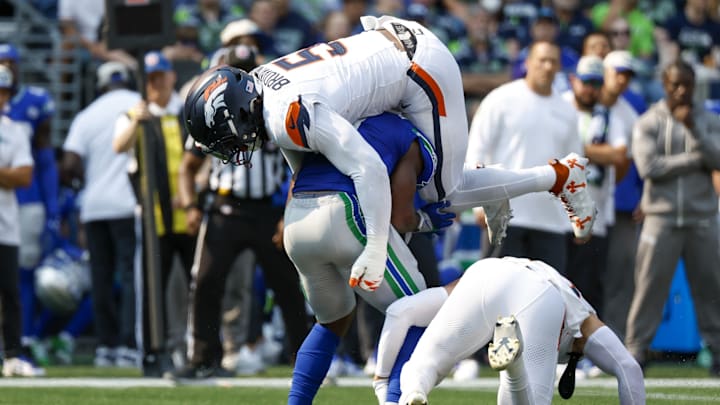 Sep 8, 2024; Seattle, Washington, USA; Denver Broncos linebacker Baron Browning (5) tackles Seattle Seahawks running back Kenneth Walker III (9) during the second quarter at Lumen Field. 