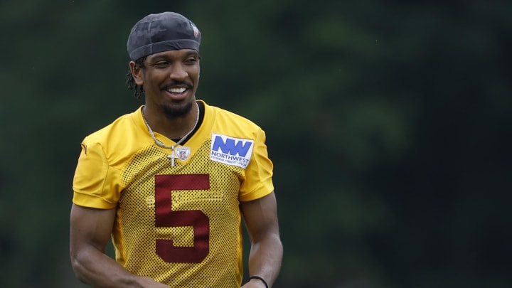 Jun 5, 2024; Ashburn, VA, USA; Washington Commanders quarterback Jayden Daniels (5) smiles on the field during an OTA workout at Commanders Park. Mandatory Credit: Geoff Burke-USA TODAY Sports