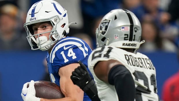 Colts wide receiver Alec Pierce (blue jersey; white helmet) runs away from a tackler after a big catch. 