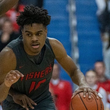 Fishers High School's guard Jalen Haralson (10) is defended by Hamilton Southeastern High School's guard Deion Miles (5) at Carmel High School, Tuesday, Feb. 28, 2023, during the Fishers boys    sectional win over HSE, 68-49.