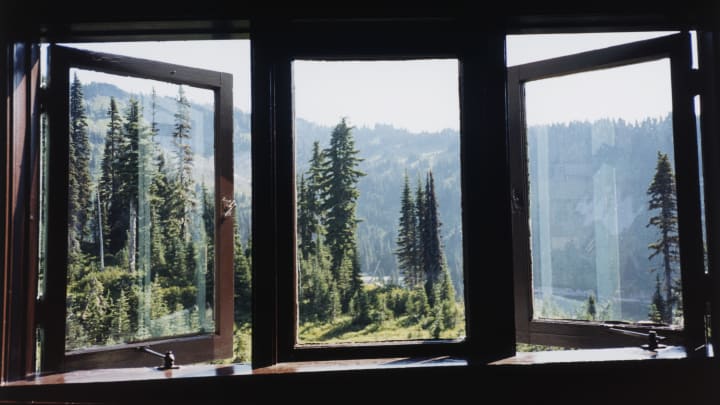Open windows looking out on trees and mountains