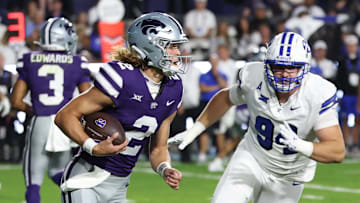 Sep 21, 2024; Provo, Utah, USA; Kansas State Wildcats quarterback Avery Johnson (2) runs from Brigham Young Cougars defensive tackle John Nelson (94) during the first quarter at LaVell Edwards Stadium. Mandatory Credit: Rob Gray-Imagn Images