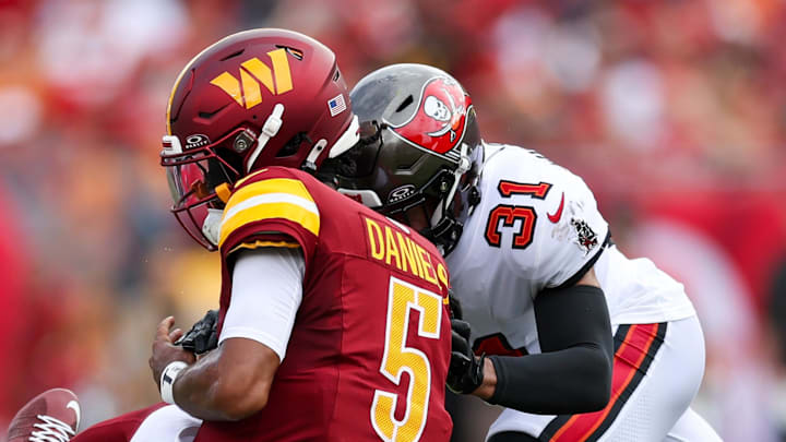 Sep 8, 2024; Tampa, Florida, USA; Washington Commanders quarterback Jayden Daniels (5) is hit by Tampa Bay Buccaneers safety Antoine Winfield Jr. (31) in the second quarter at Raymond James Stadium. Mandatory Credit: Nathan Ray Seebeck-Imagn Images